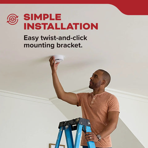 Hardwired Smoke Detector With Ten Year Battery Backup For 120V Homes 85 dB Alarm Red LED Visual Warning Model 20SA10 Three Pack Detects Smoke Faster To Keep Your Crew Safe. man installing ceiling smoke detector