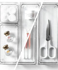 4 Piece Modular Drawer Bin Set For Bathroom And Vanity Organization Small Plastic Organizer Bins with various items like cotton balls and scissors.