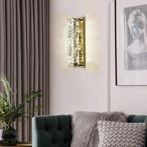 Lit Crystal Glass Wall Sconce In Gold Finish, Mid Century Modern Lighting on a living room wall, emitting soft light