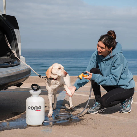 Woman washing dog with High Pressure 5L Portable Shower Kit Hand Pump 45 PSI No Power Needed for Camping Outdoor Rinse Beach Dog Wash