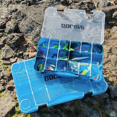 Clear Plastic Fishing Tackle Box Organizer Set Four Pack With Removable Dividers And 3600 Tackle Trays on rocky shore