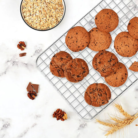Cookies on stainless steel baking sheet with wire rack for toaster oven, 10.5 by 8.3 inches, surrounded by ingredients.