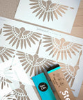 Art Deco Cranes Wall Stencils 2 Pack Large 16.7 By 22.5 Inch Boho Pattern For Painting Walls shown with packaging on a table