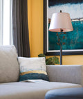 Ashlen Oil Rubbed Bronze Table Lamp With Gold Tapered Shade Rustic Living Room Lighting beside gray couch, art in background.