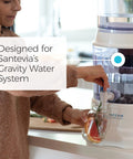 Person using Replacement Filter For Gravity Water System That Reduces Fluoride And Chlorine, Builds Alkaline Water.