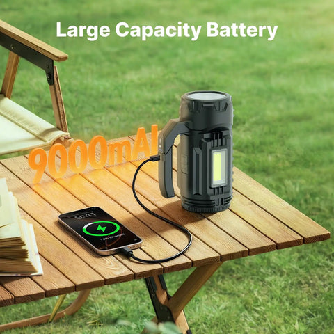 Rechargeable All In One Camping Lantern And Flashlight with 9000 mAh battery on outdoor table charging a phone