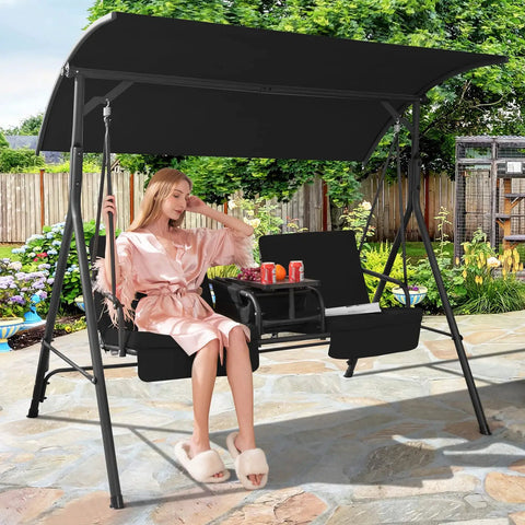 Woman relaxing on a two person outdoor porch swing with canopy, storage table, cooler bag, and cup holders, black