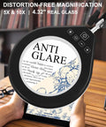 Distortion-free 5X/10X illuminated magnifier lamp with dimmer, handheld use for crafting, anti-glare, clamp visible.