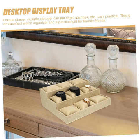Slick Nine Grid Linen Watch Organizer Tray With Snug Padded Pillows displaying watches on a wooden vanity with jewelry.