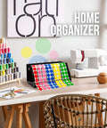 Rock Solid Acrylic Label Dispenser With Grippy Non Slip Base keeps sticker rolls tidy in a colorful home workspace.