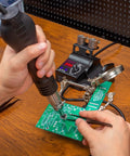 Compact Hot Air Rework Station Kit With Integrated Nozzle Holder in use for precise PCB soldering with tweezers
