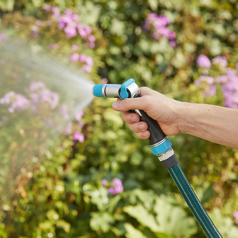 Medium Duty Thumb Control Garden Hose Nozzle With Adjustable Spray Pattern For Lawn And Garden in use spraying plants
