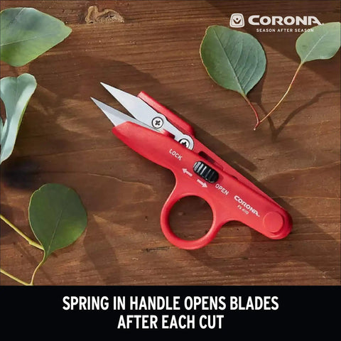 Hydroponic Finger Micro Snips With Precision Micro Tip Blades on wooden surface, surrounded by green leaves