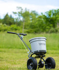 Beast 50 Lb Walk Behind Spreader For Lawn Care, 10 To 12 Foot Coverage, shown on grass with durable composite hopper