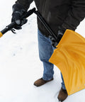 Person holding 18 Inch Collapsible Poly Snow Shovel With Metal Wearstrip in snow, adjustable handle visible, ready for use.
