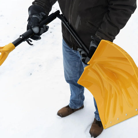 Person holding 18 Inch Collapsible Poly Snow Shovel With Metal Wearstrip in snow, adjustable handle visible, ready for use.