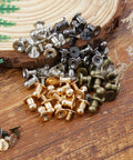 Supercharge Your Daily Craft Gear With Slick Heavy Duty Metal Button Studs And Rivets Perfect For Leather Work Sewing And Dope Accessory Making Premium Zinc Alloy Mixed Silver Gold Black Bronze Shiny Finish One Hundred Piece Set, assorted rivet colors on wood background.