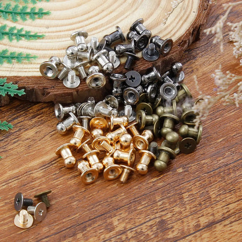 Supercharge Your Daily Craft Gear With Slick Heavy Duty Metal Button Studs And Rivets Perfect For Leather Work Sewing And Dope Accessory Making Premium Zinc Alloy Mixed Silver Gold Black Bronze Shiny Finish One Hundred Piece Set, assorted rivet colors on wood background.