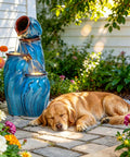 Outdoor Ceramic Water Fountain With 4 Tier Pots Turquoise Ocean Wave Texture 29 Inch Garden Centerpiece next to a sleeping dog