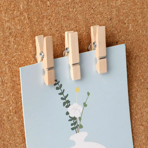 100 Piece Natural Wood Push Pin Clip Set Includes Clear Tube To Tidy Up Papers And Memos No Fuss Thumb Tacks For Clean Desk Setup Goals, holding a note.