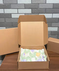 Heavy Duty 20 Pack Of 10X10X3 Inch Brown Corrugated Cardboard Shipping Boxes with smooth finish edges opened on a table.