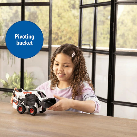Child playing with Bobcat 1/16 Scale Skid Steer Loader Diecast Toy With Fully Functional Front Loader And Tilt Bucket inside room.