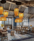 Lantern Style LED Pendant Light With Adjustable Cord Bamboo Weave Ceiling Hanging Lamp illuminating a rustic dining room