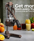 Heavy Duty Cast Iron Citrus Juicer Press with detachable strainer squeezing fresh juice from oranges and limes.