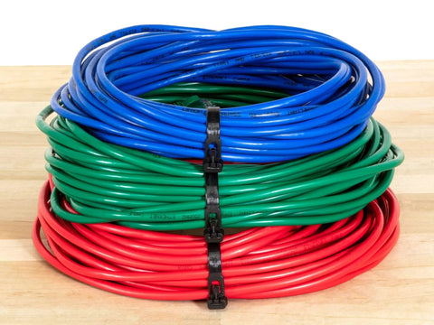 Heavy Duty 12 Inch Black Releasable Cable Ties 100 Pack Nylon 66 Zip Ties organizing blue, green, and red cables on a wooden surface.