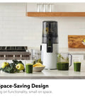 Hurom H70 Cold Press Juicer Easy To Clean Masticating Slow Juicer with green juices and ingredients on a kitchen counter.