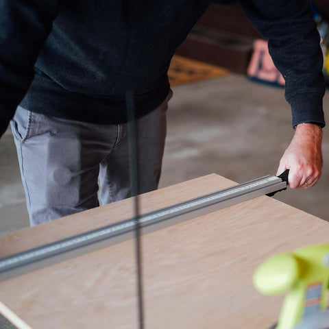 Person using Aluminum Pro Grip Clamp Straight Edge Wood Cutting Guide For Table Saw Up To 50 Inches for a precise cut