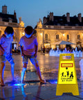 Kids playing near a fountain at night with a Four Pack 24 Inch Slow Down Kids At Play Sign Reflective Double Sided Street Safety Sign