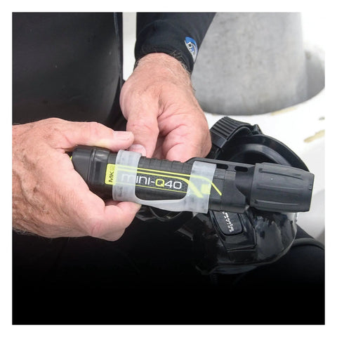 Hands holding MiniQ40 MK2 Dive Light 250 Lumens Hand Free Underwater Torch With Mask Strap 5 Hour Run Time Push Button Rear Switch