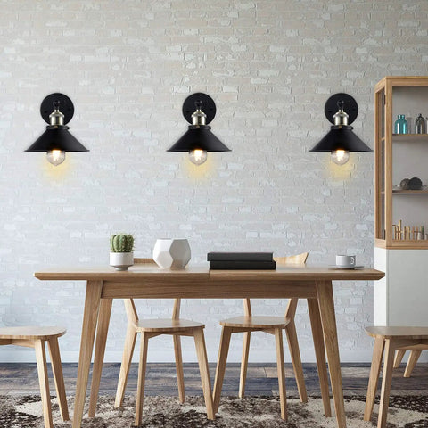 Dope Industrial Vintage Black Wall Sconces Set Of 3 Hardwired With Adjustable Heads mounted on a white brick wall above a table.