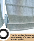 Black plastic Roman blind curtain ring O ring attached to a gray fabric blind, used as a cord guide for window treatments.