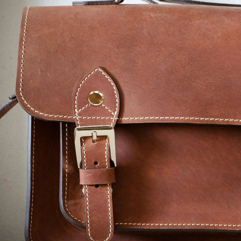 Premium Copper Binding Screw Posts Give Your Office Documents A Top Shelf Makeover With Rock Solid Metal Construction that showcases a brown leather satchel with a buckle.