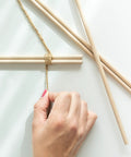 Premium Unfinished Hardwood Dowel Rods 1/4 X 12 Inches Ten Pack Smooth Finish Round Wooden Sticks being tied with twine in craft project.