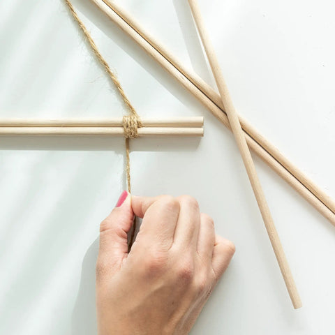 Premium Unfinished Hardwood Dowel Rods 1/4 X 12 Inches Ten Pack Smooth Finish Round Wooden Sticks being tied with twine in craft project.