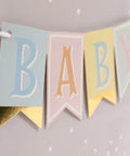 Baby banner with foil accents on silver dots for medium baby gift bag with tissue paper in pink blue grey theme, yellow ribbon handle