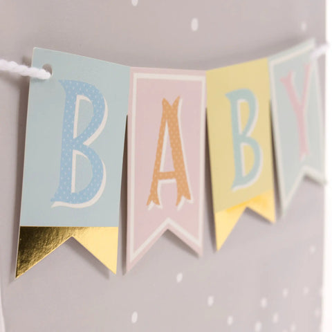 Baby banner with foil accents on silver dots for medium baby gift bag with tissue paper in pink blue grey theme, yellow ribbon handle