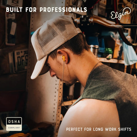 Man wearing Ruckus Wireless Bluetooth Earbuds With 25 dB Noise Reduction And Noise Cancelling Mic 12 Hour Battery IP65 Sweatproof OSHA Compliant Hearing Protection For Work Safety In Loud Environments in workshop.