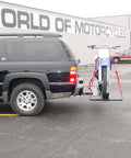 Dirt Bike Hitch Carrier With Ramp For 2 Inch Class III And IV Hitches, Up To 500 Lb Capacity, Includes Ramp And Four Tie Down Eyelets For Secure Motorcycle Transport mounted on an SUV.