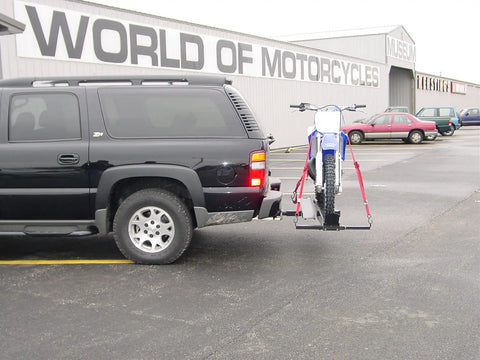 Dirt Bike Hitch Carrier With Ramp For 2 Inch Class III And IV Hitches, Up To 500 Lb Capacity, Includes Ramp And Four Tie Down Eyelets For Secure Motorcycle Transport mounted on an SUV.