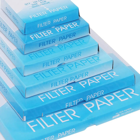 Stack of blue boxes labeled 'Filter Paper' containing Pro Grade Qualitative Filter Paper 12.5 Cm Diameter Medium Speed 85 GSM 10 Micron Pore Size Pack Of 100 For Lab Filtration Great For Chemistry And Bio Experiments Reliable Quality For Qualitative Analysis standing over white background