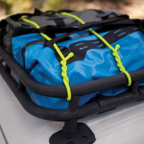 Gear Tie Mega Rubber Twist Tie 32 Inch Bright Orange secures blue tarp on roof rack, strong bendable wire core visible.