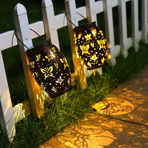 Butterfly Solar Powered Outdoor Metal Lanterns Set Of 2 Waterproof Hanging Patio Lights casting butterfly shadows on pathway
