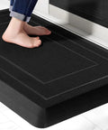 Person standing on Extra Thick Anti Fatigue Kitchen Mat 0.9 Inch Cushioned Standing Desk Mat with Waterproof High Density Foam Non Slip Ergonomic Comfort Mat for Kitchen Office Workstation 20 by 32 Inches Black