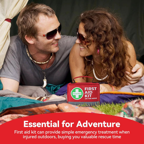 Front view of a red General Medi First Aid Kit with a green cross logo on grass near two campers.