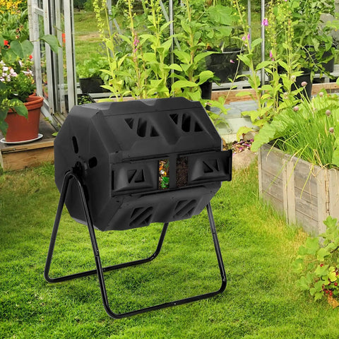 43 Gallon Outdoor Tumbling Compost Bin With Dual Chamber Sliding Doors for Garden and Patio on grass near garden beds.