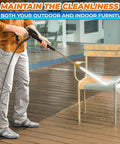 Pressure washer in use cleaning a metal outdoor chair on a wooden deck; spray nozzle visible.